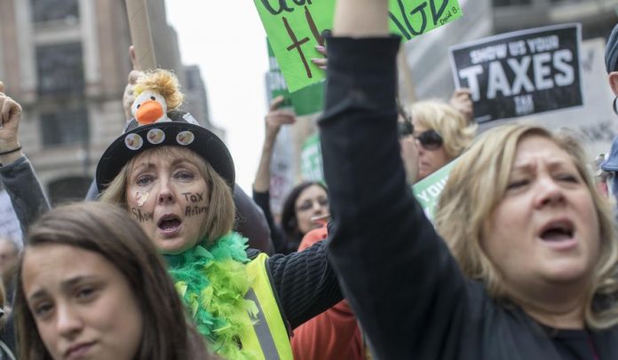 Donald Trump says tax march protesters were paid