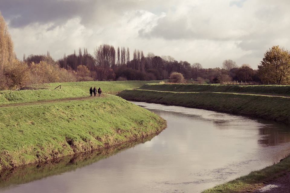 People walking alongside River Mersey 