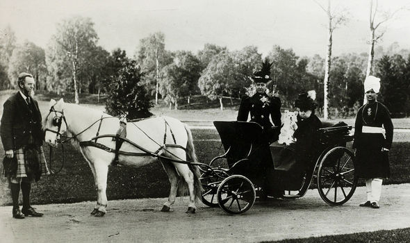 Karim (far right) stands next to Victoria as she sits in a carriage Karim (far right) stands next to Victoria as she sits in a carriage