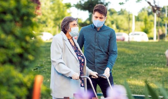 Young man helping senior woman walking in the street