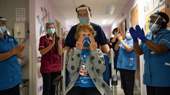 Margaret Keenan, 90, is applauded by staff as she returns to her ward