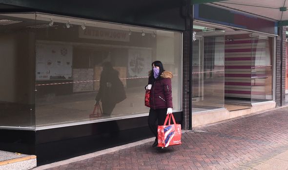 Woman walks past closed shops Woman walks past closed shops