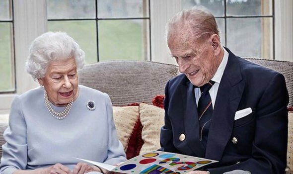 The Queen and Prince Philip looking at their anniversary card from their great-grandchildren The Queen and Prince Philip looking at their anniversary card from their great-grandchildren