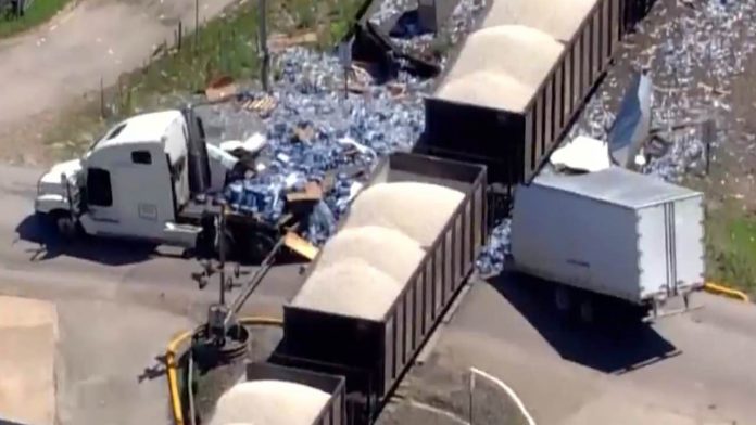 Semi carrying water bottles split in half by train (Video)